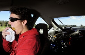 Man driving while eating from a bag